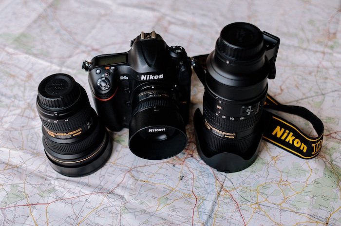 Аббревиатуры объективов Nikon: Камера Nikon и два дополнительных объектива сидят на карте