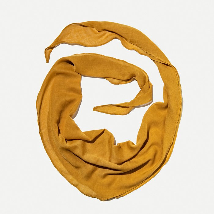 Flat Lay Photography of Clothing: A flat lay image of a mustard scarf laid in the circular pattern