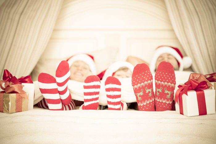 Рождественские носки и подарки в конце кровати для рождественской открытки фото идеи