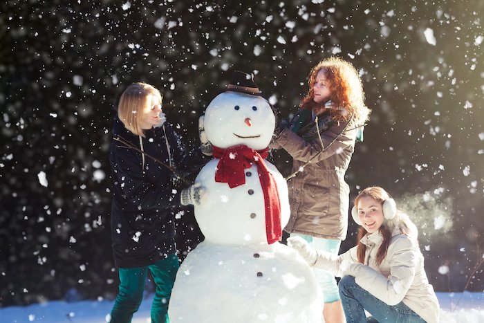 Строим снеговика с семьей для рождественской открытки фото идеи