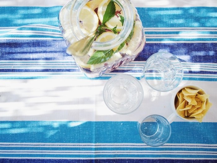 Lemon water and glasses shot from above on the striped food photography prop tablecloth