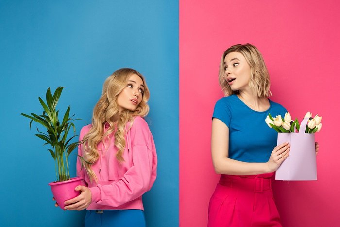 Две девушки держат растения в студии идея фотосессии сестер
