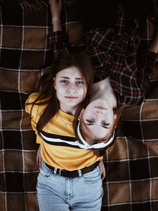 идеи фотосессии сестер: две девочки на одеяле, сфотографированные сверху