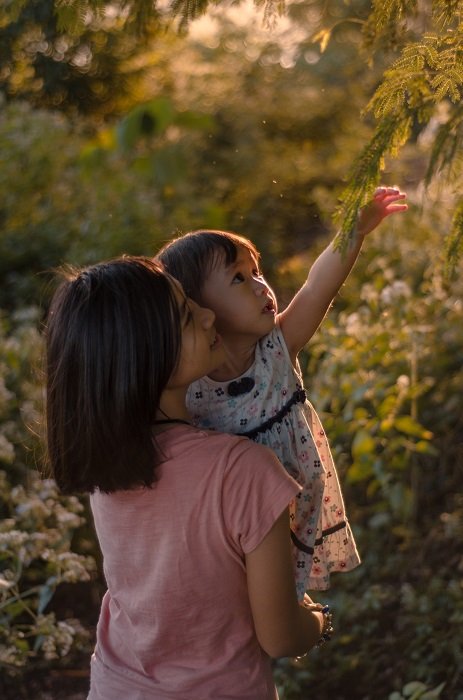 Одна девушка несет младенца в лесу как идея сестринской фотосессии