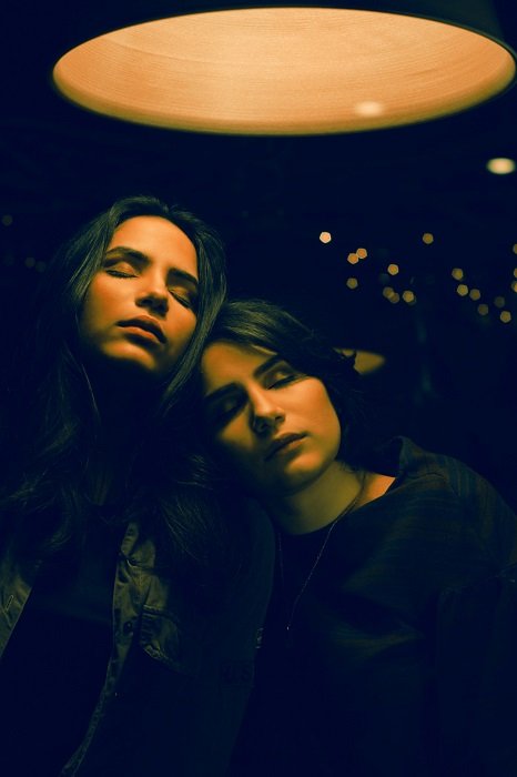 Идеи сестринской фотосессии: Две девушки под лампой в угрюмой обстановке