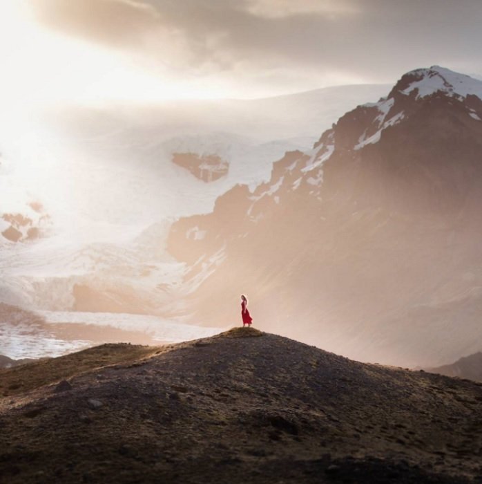 Женщина, стоящая на вершине холма в горном пейзаже, как пример сказочной фотографии