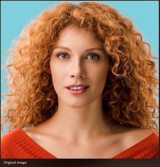Крупный план женщины с рыжими вьющимися волосами и голубыми глазами