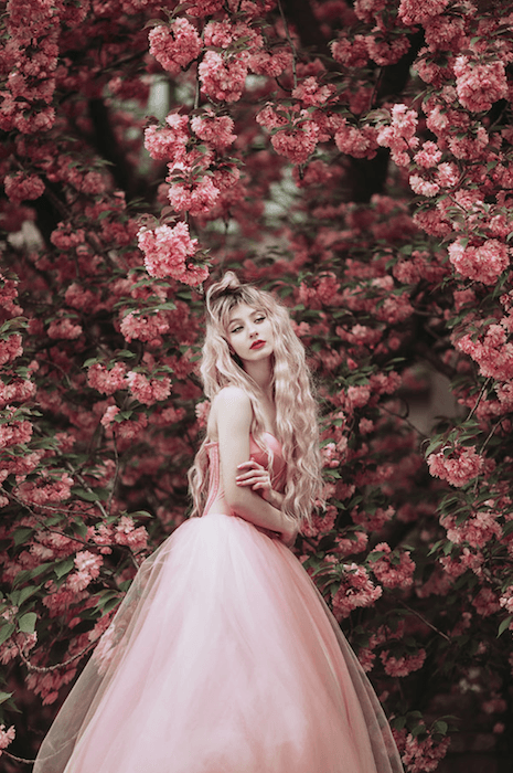 цветочная фотосессия женщины в розовом платье, позирующей с розовыми цветами