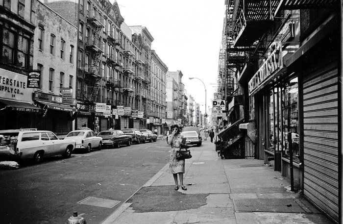 Черно-белая фотография женщины, идущей по городской улице