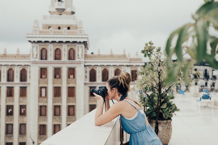 Женщина-фотограф делает снимок на крыше здания