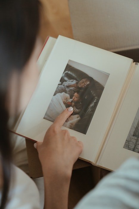 Женщина просматривает фотоальбом с фотографией 4x6