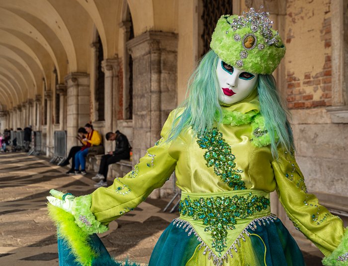 Венецианская модель в маске в зеленом наряде