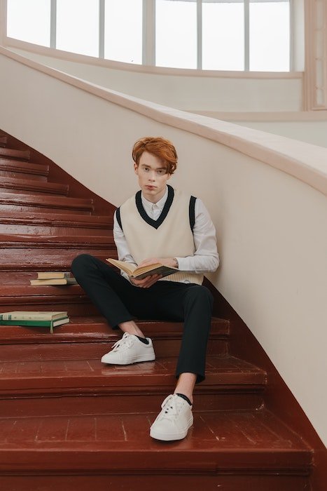 мужчина сидит на лестнице с книгами как идея для мужских поз