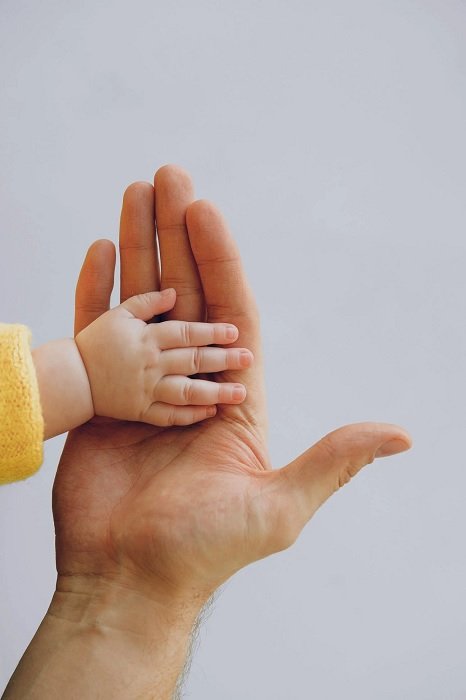 Рука ребенка в руке взрослого как идея фото новорожденного