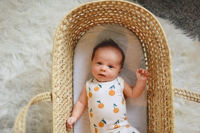 Ребенок в плетеной корзине как идея для фото новорожденного