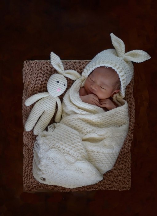 Идея фото новорожденного ребенка в вязаной одежде с соответствующей игрушкой