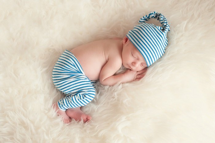 Ребенок лежит на пушистом одеяле как идея для фотосессии новорожденных