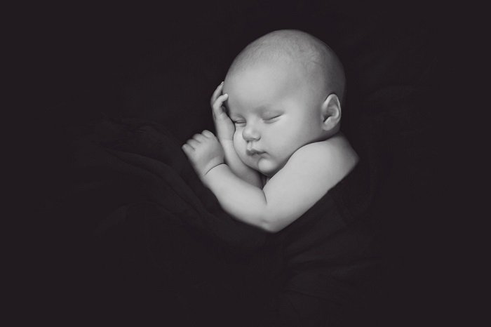 Черно-белое фото ребенка в одеяле как идея для фотосессии новорожденного