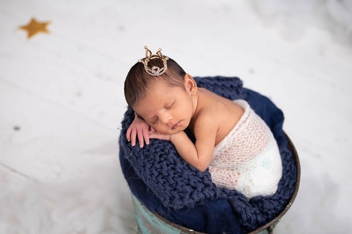 Девочка с крошечной короной на голове как пример идеи фото новорожденных