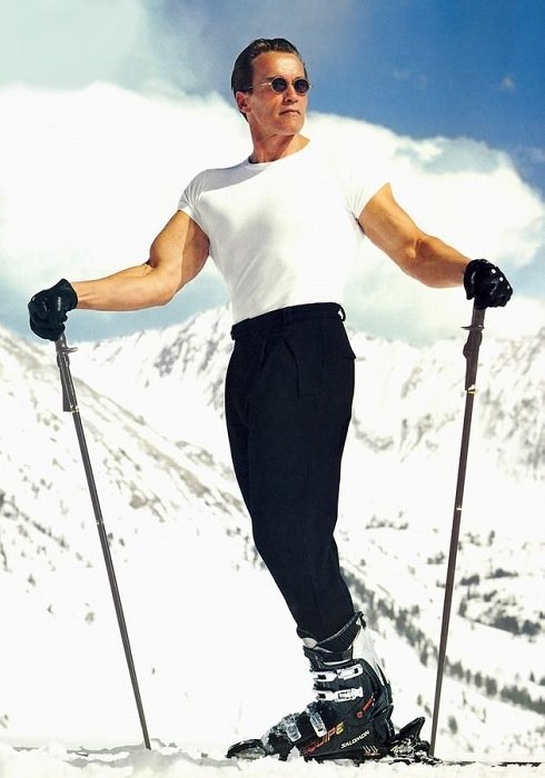 Арнольд Шварценеггер на лыжах на фоне белых заснеженных гор