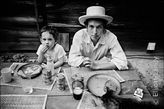 Bob Dylan and his son sitting at a table
