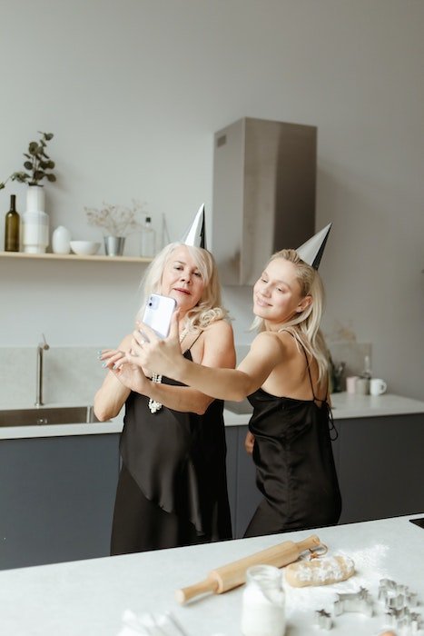 Две женщины делают автопортрет во время выпечки на день рождения
