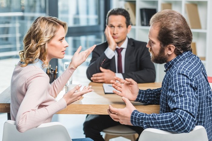 Stock photo of three people in the office having a argument