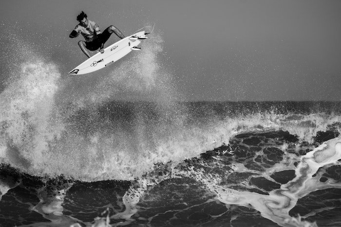 Черно-белое изображение серфингиста, выходящего на воздух