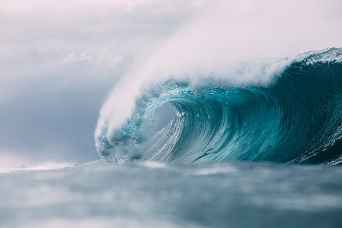 Волна разбивается о волны глубокого синего цвета