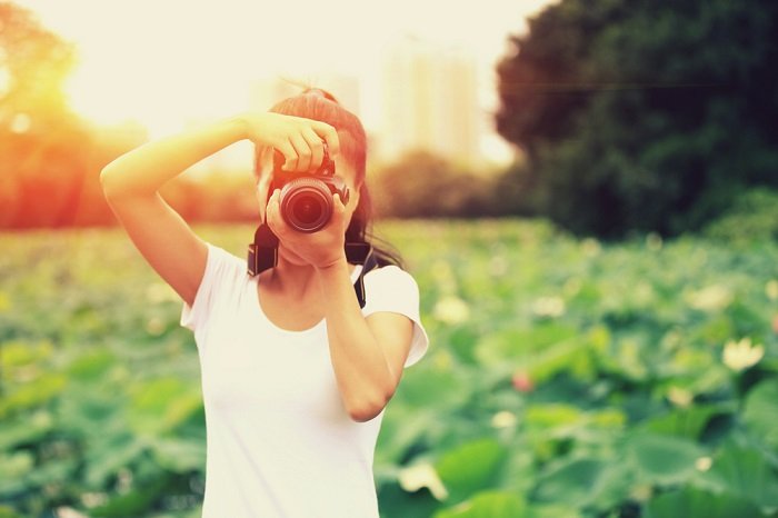 фотография женщины, фотографирующей в поле на закате солнца