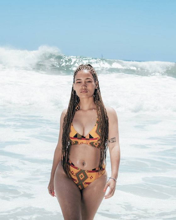 Женщина выходит из моря в бикини для пляжной фотосессии