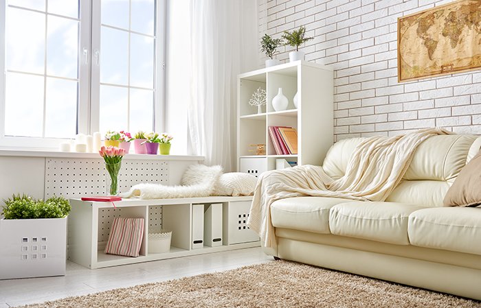 Аккуратная гостиная с белым диваном и мебелью для фотосессии недвижимости