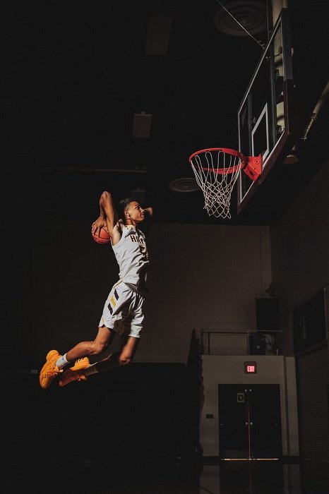 Молодой баскетболист прыгает для слэм-данка