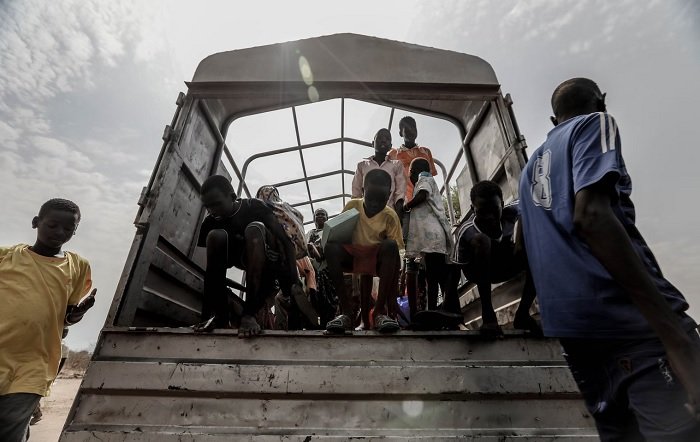 Дети, слезающие с кузова грузовика в Африке, как пример документальной фотографии