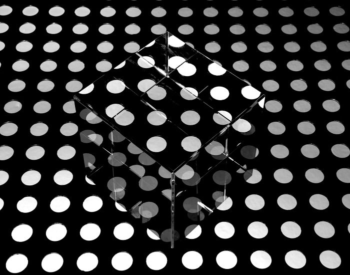 Стеклянный куб на черно-белом точечном полу, как пример fine art фотографии