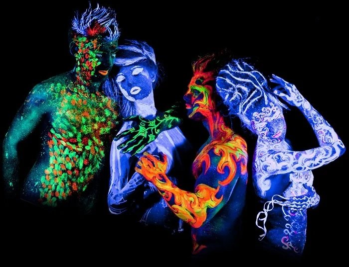 4 человека, покрытые ультрафиолетовой краской для фотографии в черном свете