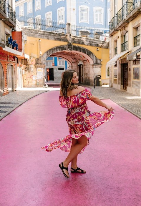 Женщина танцует в платье на красочной городской улице