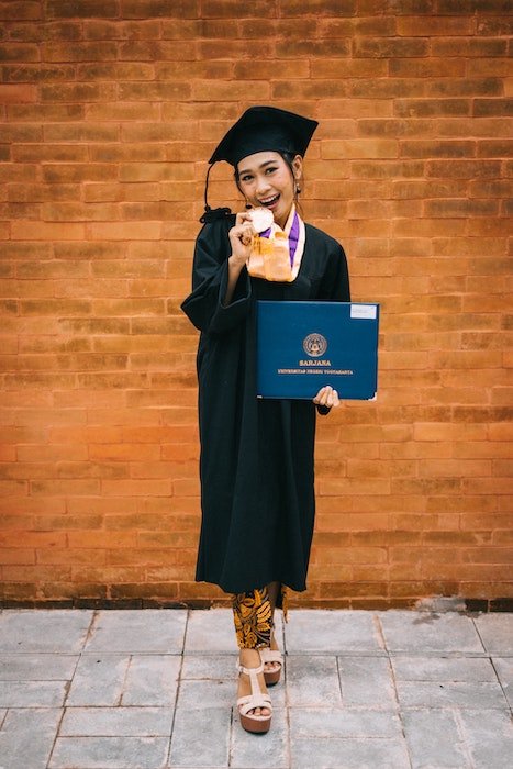 Выпускник школы держит диплом для выпускной фотосессии