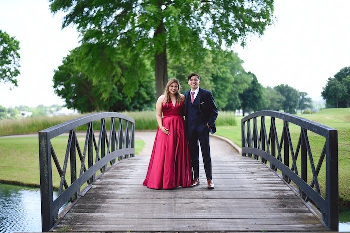 Пара, формально одетая и стоящая на небольшом мосту