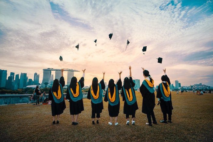 Прикольная идея выпускной фотографии выпускников школы, подбрасывающих в воздух свои выпускные шапочки