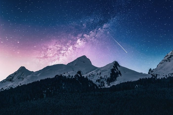 Заснеженные горы на фоне ночного звездного неба