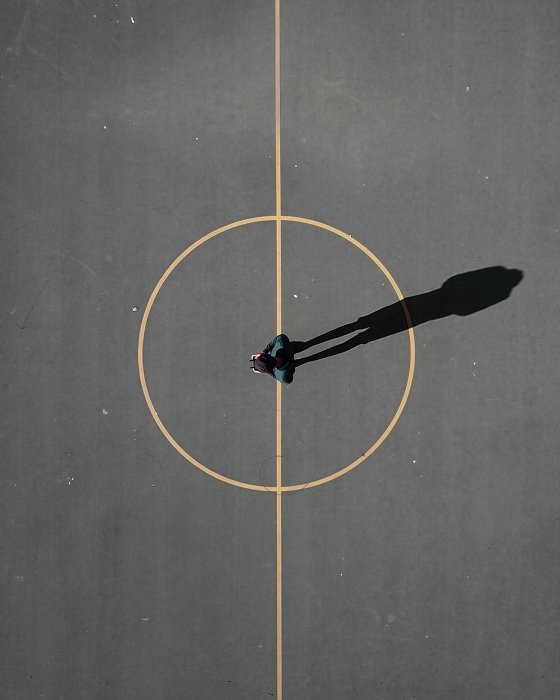 Arial снимок человека, стоящего в центральном круге бетонного поля