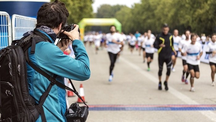 Фотограф снимает марафон с обочины