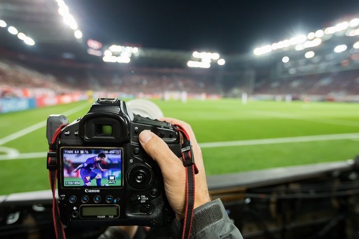 Задняя часть цифровой камеры спортивного фотографа на футбольном матче